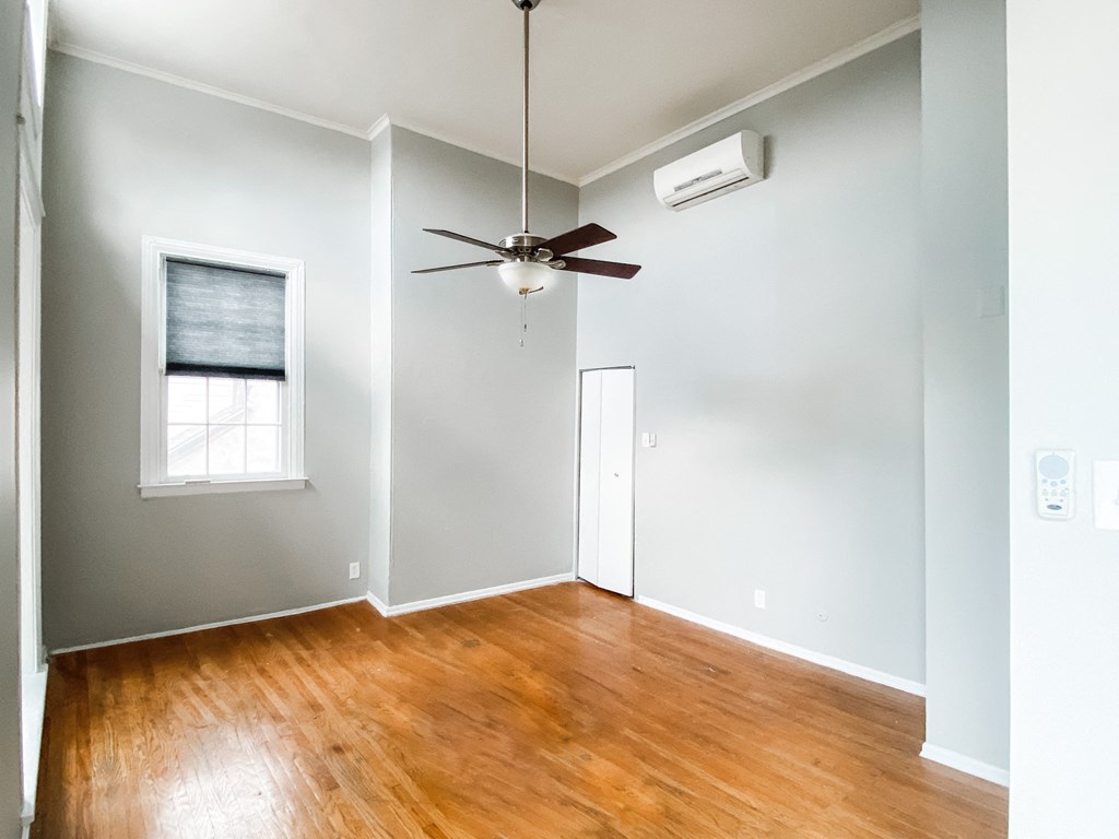 an empty living room with wood floors and a ceiling fan