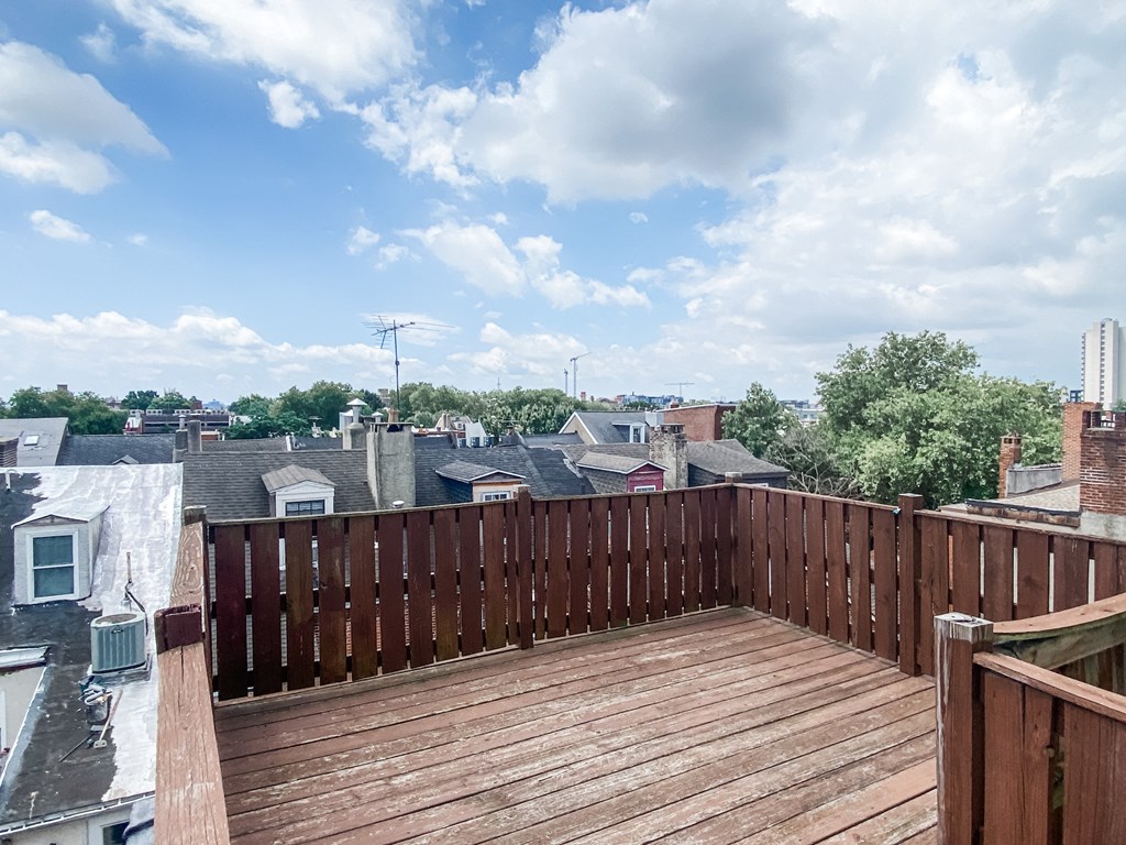 a balcony with a wooden deck and a city in the background