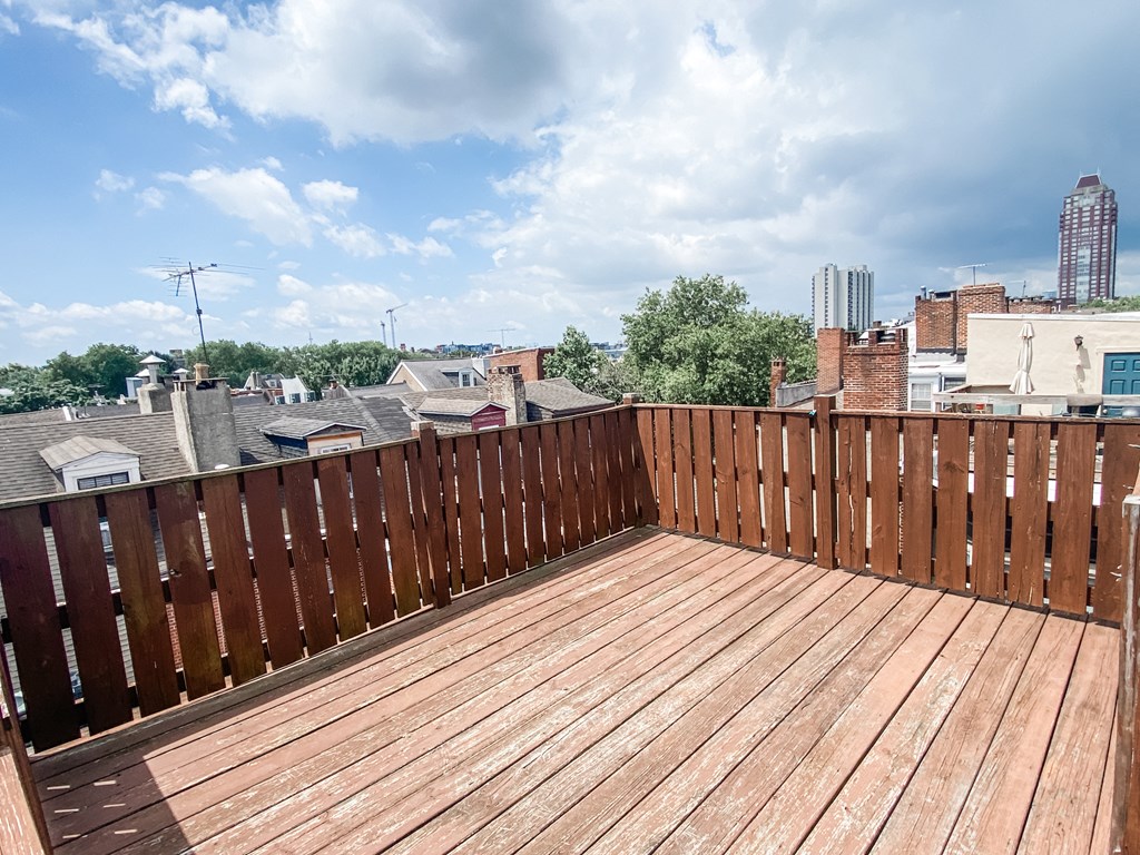 a balcony with a wooden deck and a city in the background