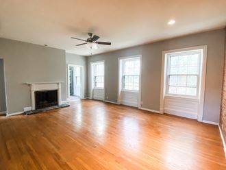 an empty living room with wood floors and a fireplace
