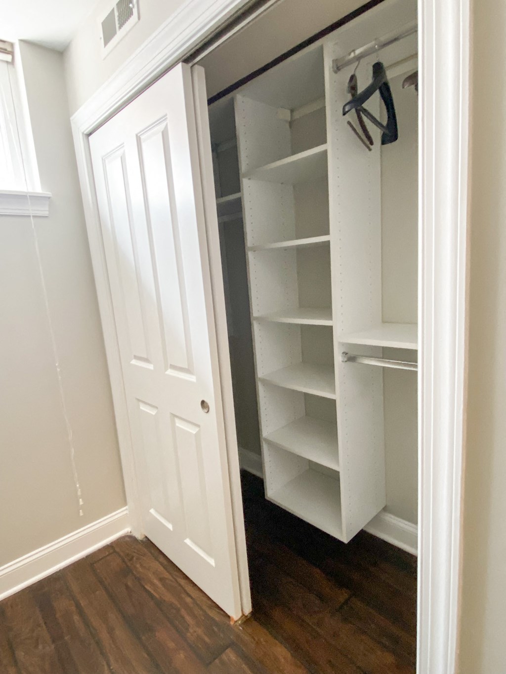 a walk in closet with a white door and shelves
