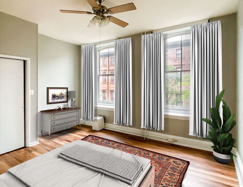 a bedroom with a bed and windows with striped curtains