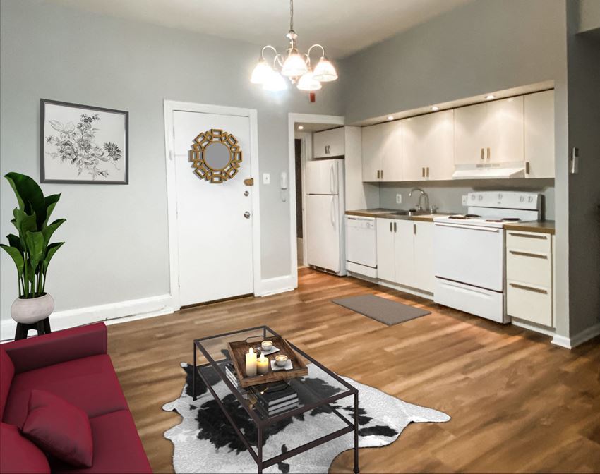 an open kitchen and living room with a red couch and a coffee table