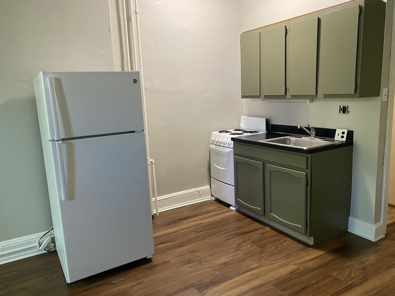 a small kitchen with a stove refrigerator and sink