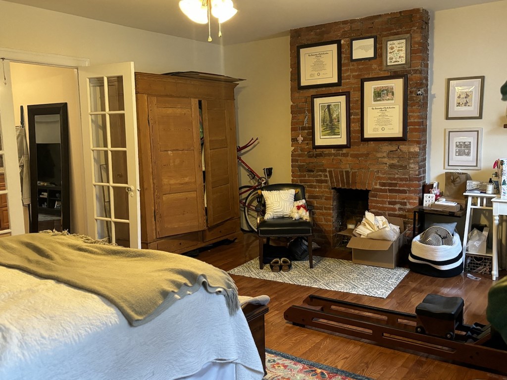 a bedroom with a bed and a brick fireplace