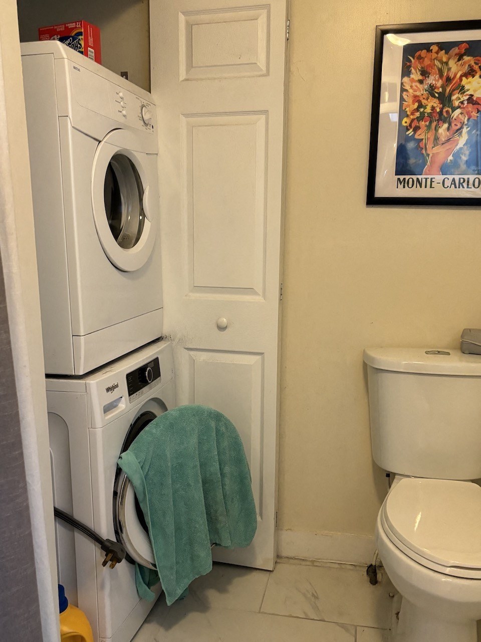 a small bathroom with a washing machine and a toilet