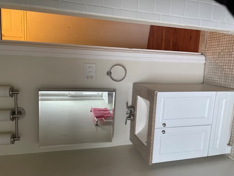 a small kitchen with a sink and a mirror