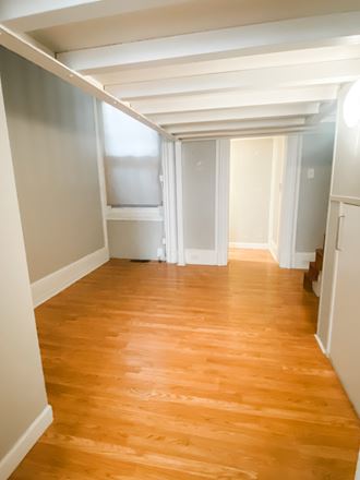 an empty living room with wood floors and a white ceiling