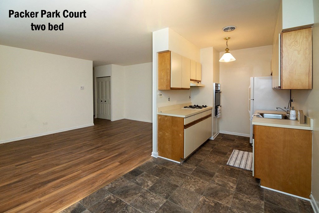 an empty kitchen and living room with wood flooring and