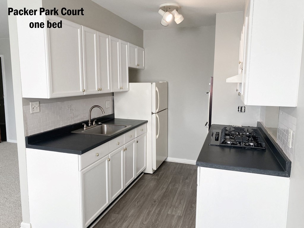 a kitchen with white cabinets and a sink and a refrigerator