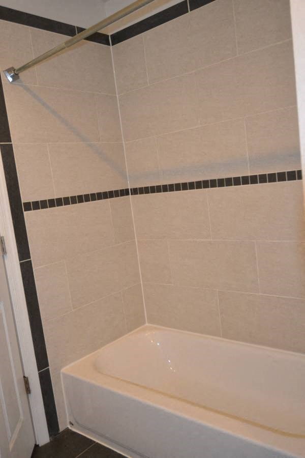 a white bathroom with a shower and a tub