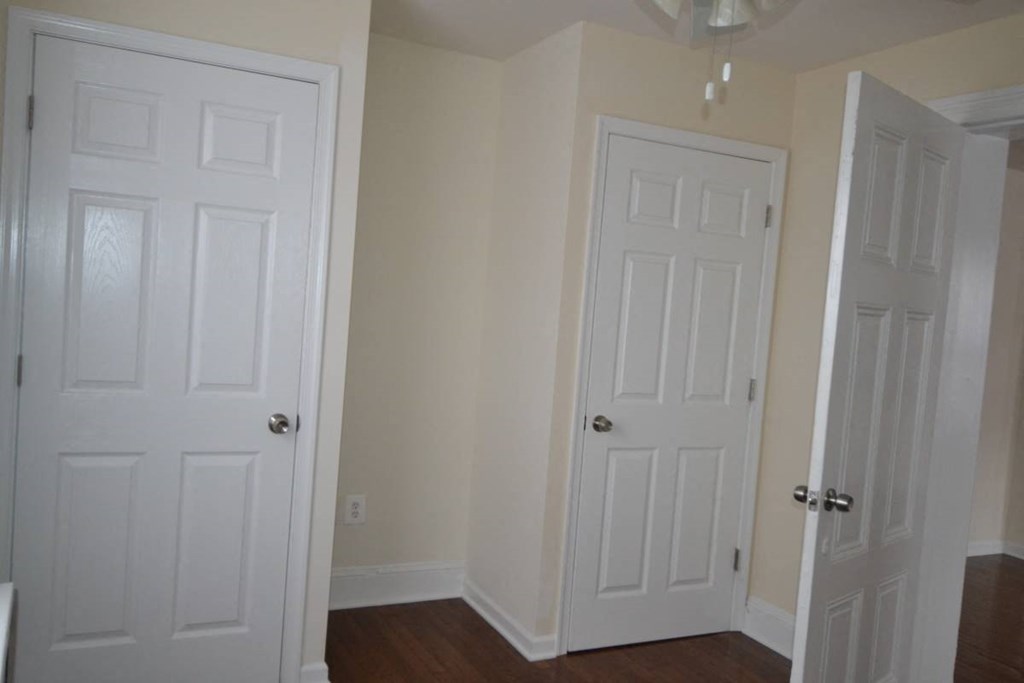 a room with two white doors and a wood floor