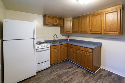 an empty kitchen with a stove refrigerator and sink