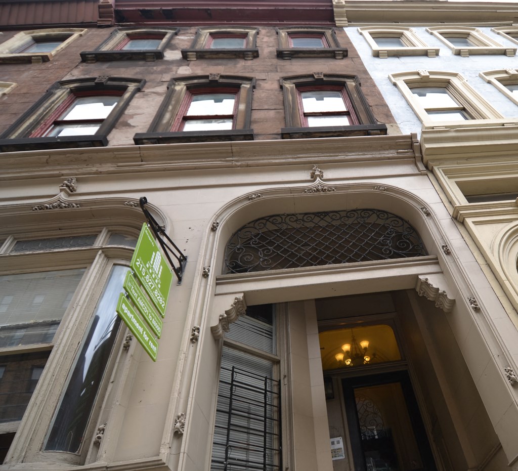 the front of a building with a green sign on it