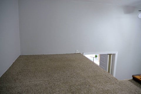 a room with a carpeted floor and a door