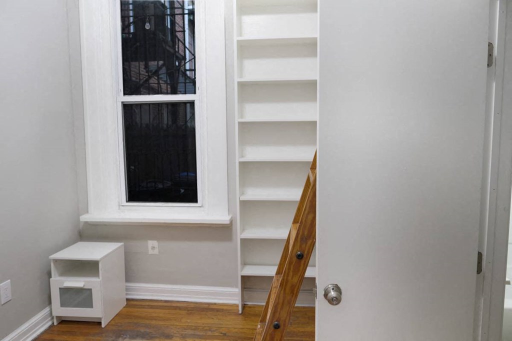 a small room with shelves and a window