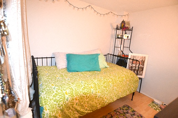 a bedroom with a bed with green pillows on it