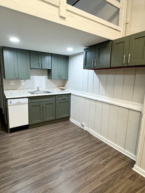 a kitchen with dark cabinets and a wooden floor