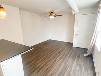 an empty living room with wood flooring and a ceiling fan