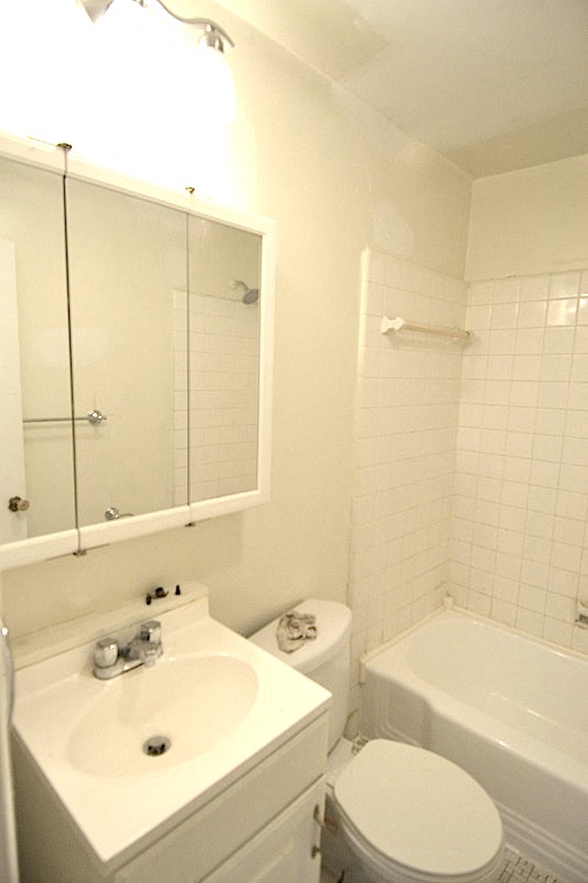 a white bathroom with a sink and a toilet