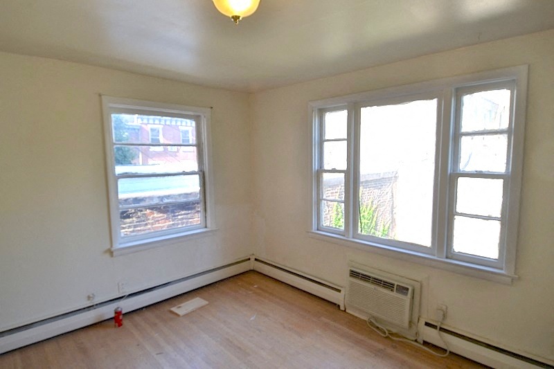 an empty room with three windows and a wooden floor