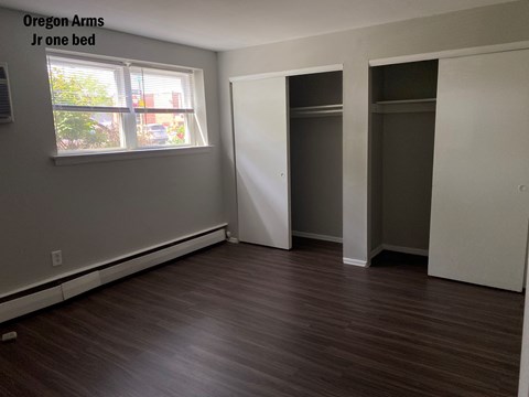 an empty room with a window and a closet