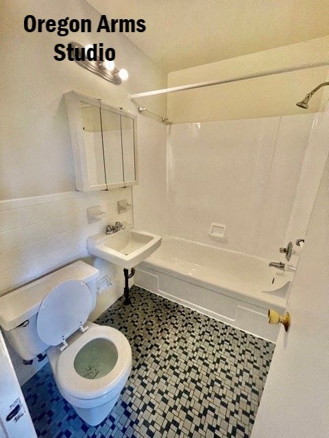 a white bathroom with a toilet and a sink