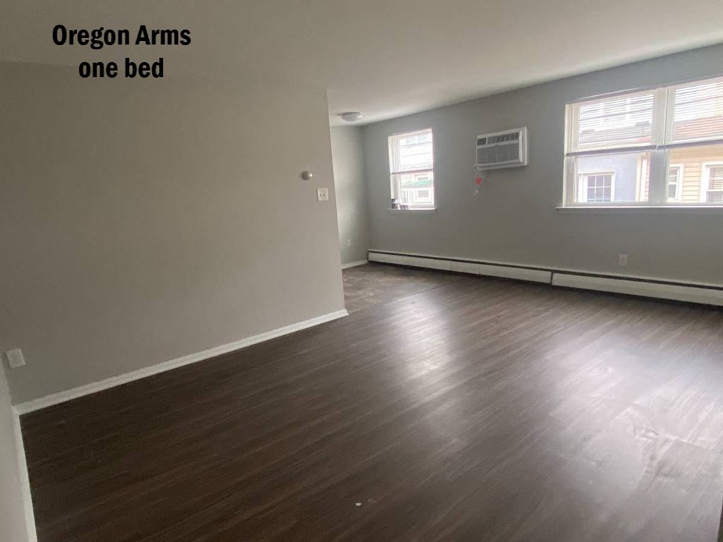 an empty living room with wood floors and    one bed