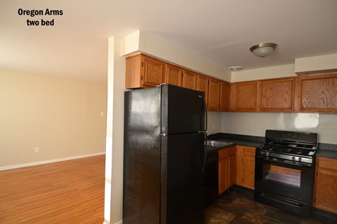 an empty kitchen with black appliances and wooden cabinets