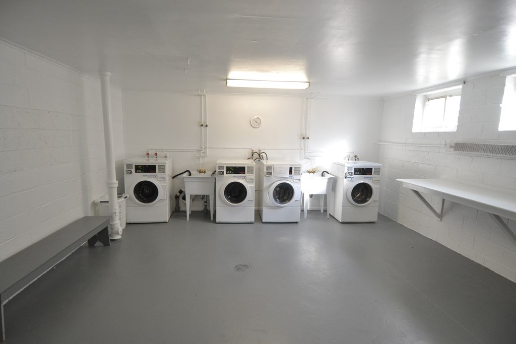 a group of washers and dryers in a laundry room