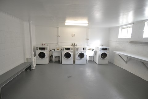 a group of washers and dryers in a laundry room