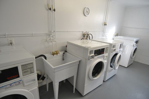 a laundry room with two washing machines and two sinks