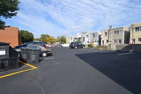 a parking lot with cars parked in front of apartment buildings