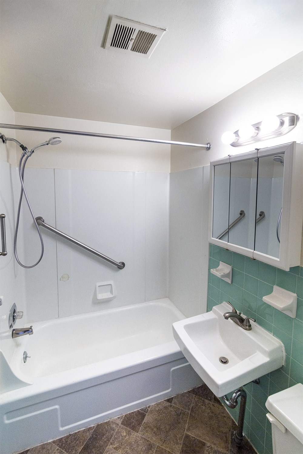 a bathroom with a tub and a sink and a mirror