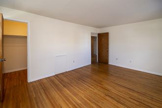 an empty living room with wood floors and white walls