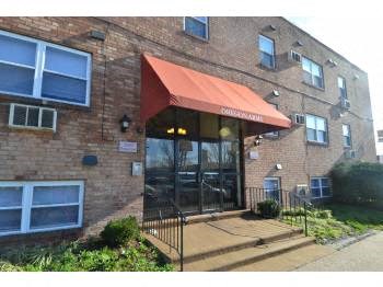 the front of a brick building with a red awning