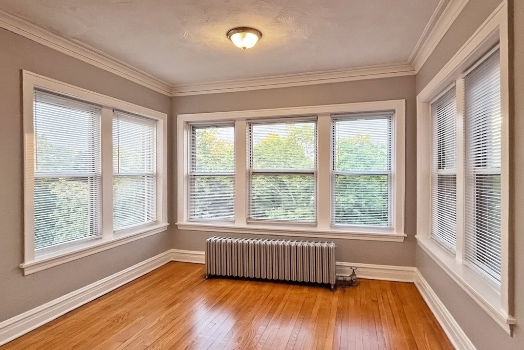 A room with wooden floors and a radiator.