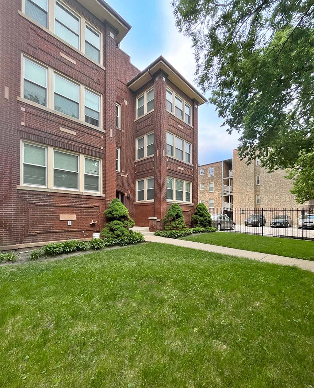 A red brick building with a green lawn in front.