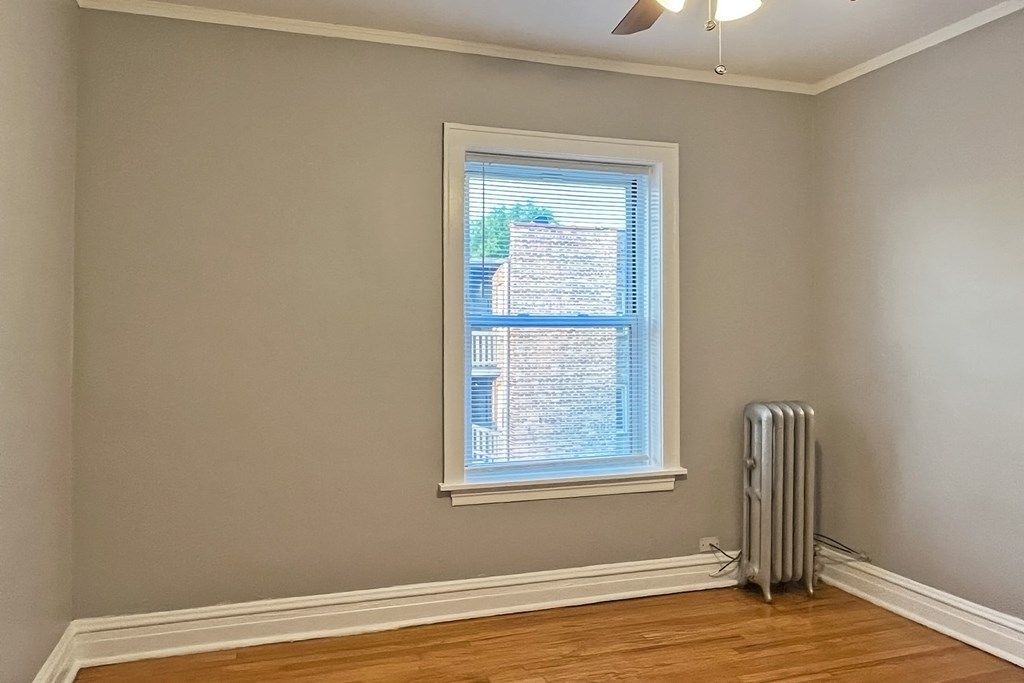 A room with a window and a fan on the ceiling.