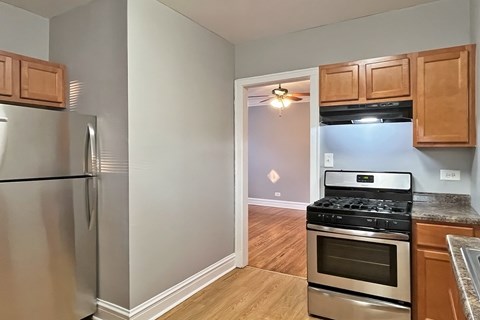A kitchen with a stainless steel refrigerator and a stove top oven.