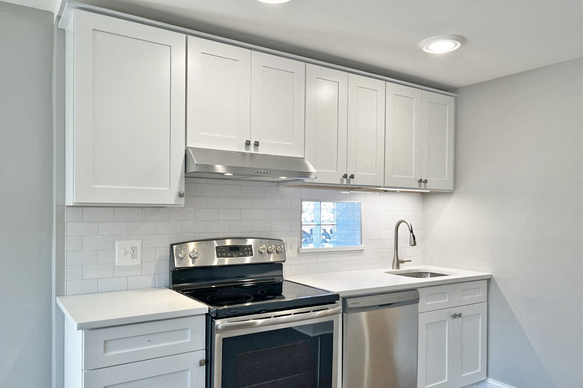 a kitchen with white cabinets and a stove and a sink