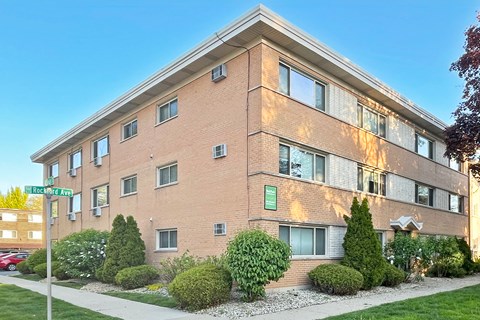 A brick building with a green sign on the front.