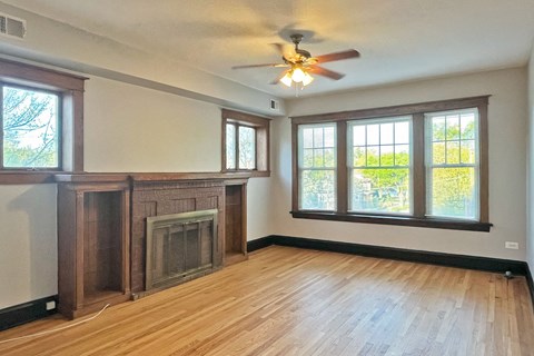 A room with a fireplace and a ceiling fan.