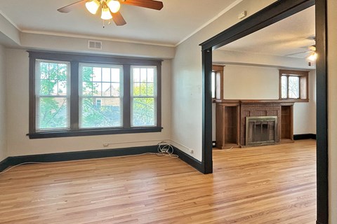 A room with a fireplace and a ceiling fan.