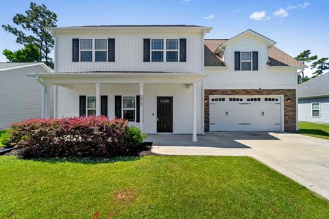 a white house with a driveway and a garage door
