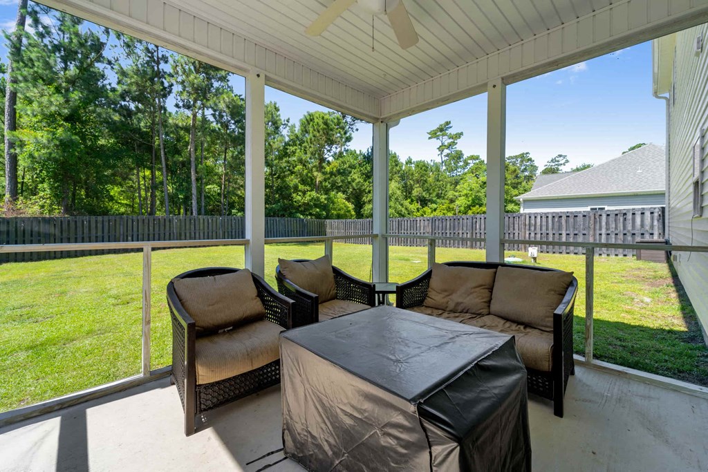 a screened in porch with a table and chairs on it