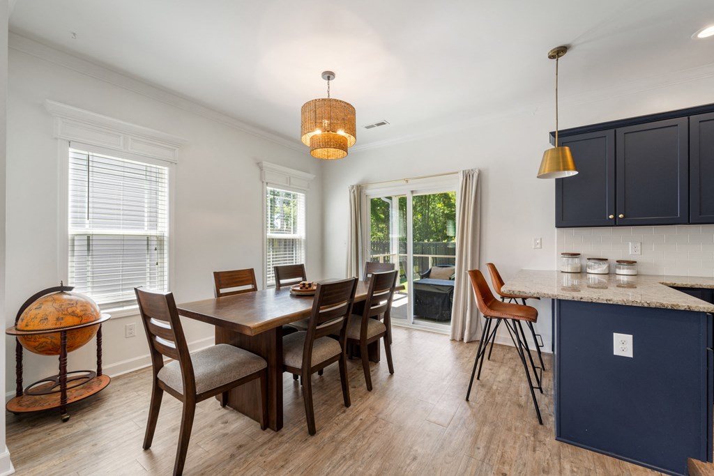 a dining room with a table and chairs and a kitchen with blue cabinets