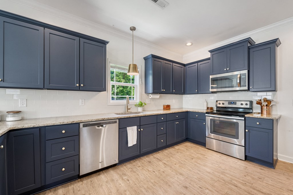 a kitchen with blue cabinets and stainless steel appliances