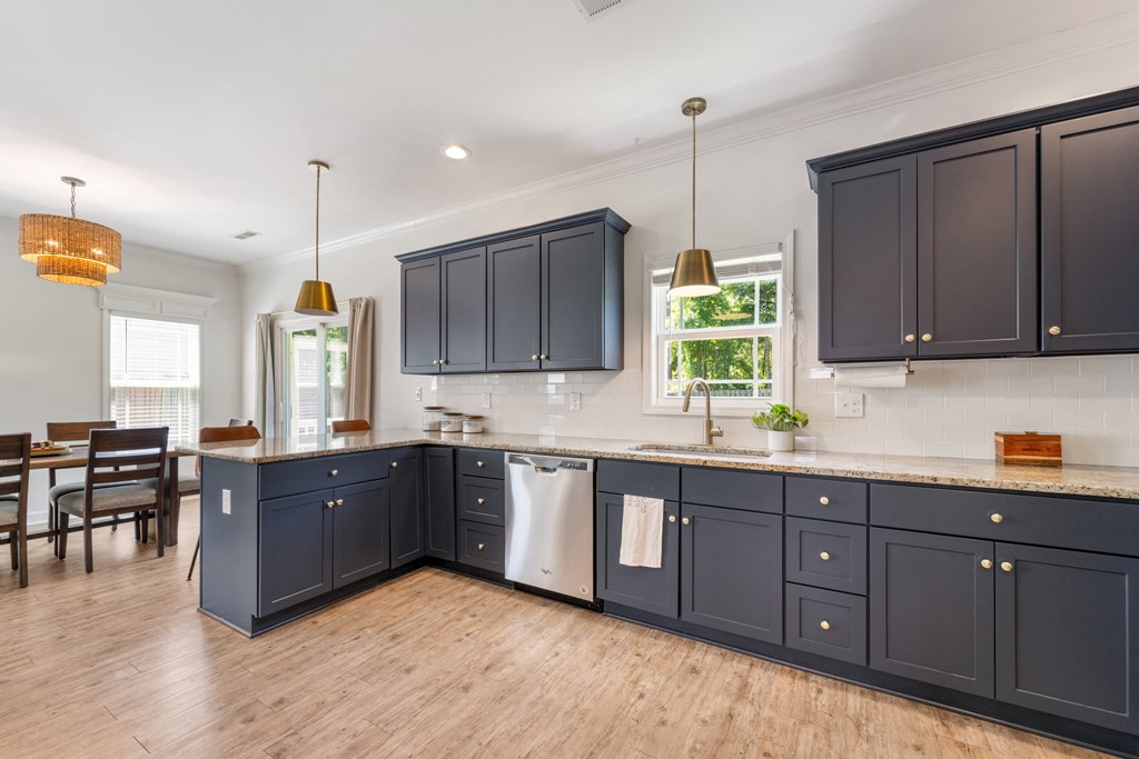 a large kitchen with blue cabinets and a wooden floor