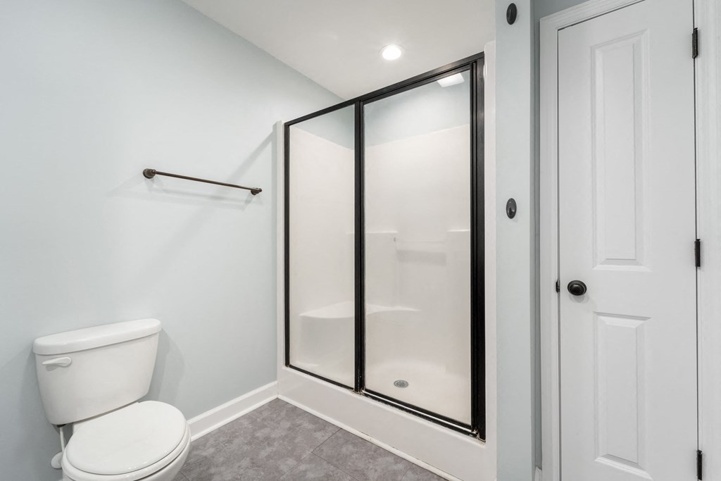 a white bathroom with a shower and a toilet